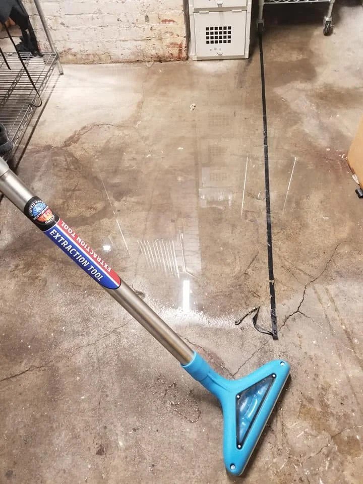 Extraction wand drawing standing water off a wet subfloor